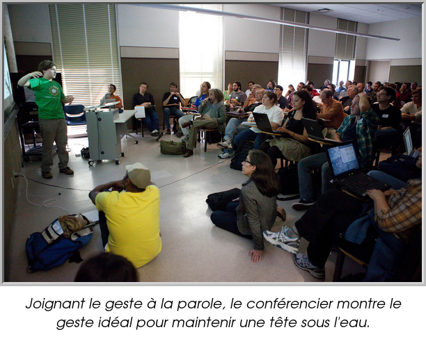 Joignant le geste à la parole, le conférencier montre le geste idéal pour maintenir une tête sous l'eau.